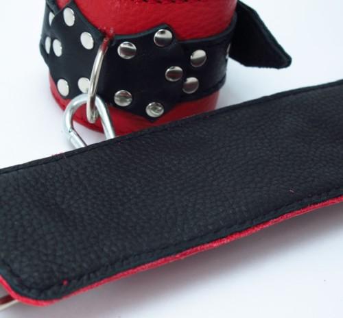 Красные наручники с чёрными проклёпанными ремешками с пряжкой от Intimcat